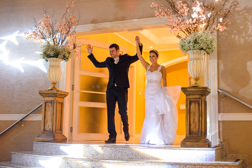 Noivos muito felizes entrando no salão de festas