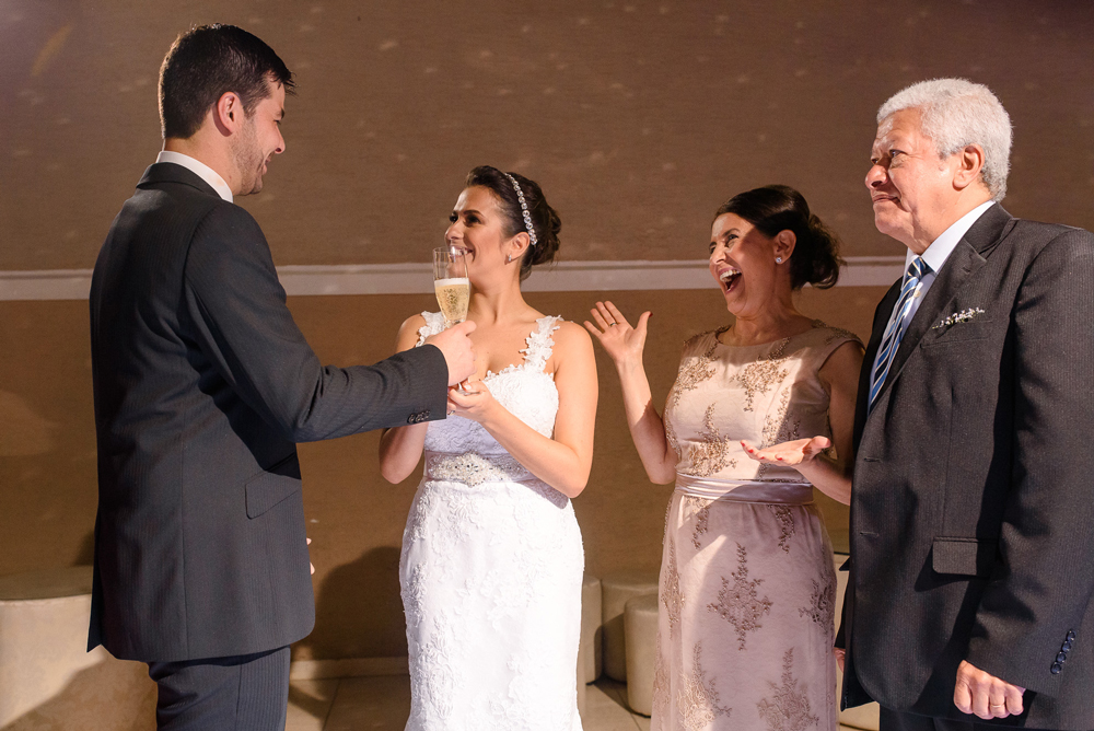 Noivos brindando junto com a sua família em um momento de muita alegria