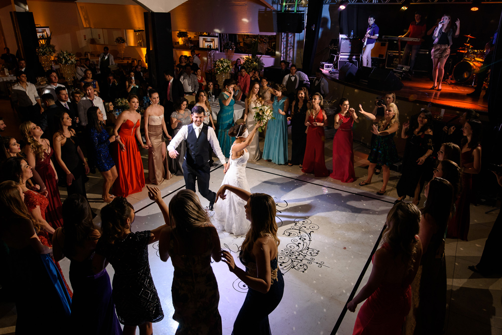 Hora do bouquet. A noiva vendada roda para entregar para uma das meninas solteiras