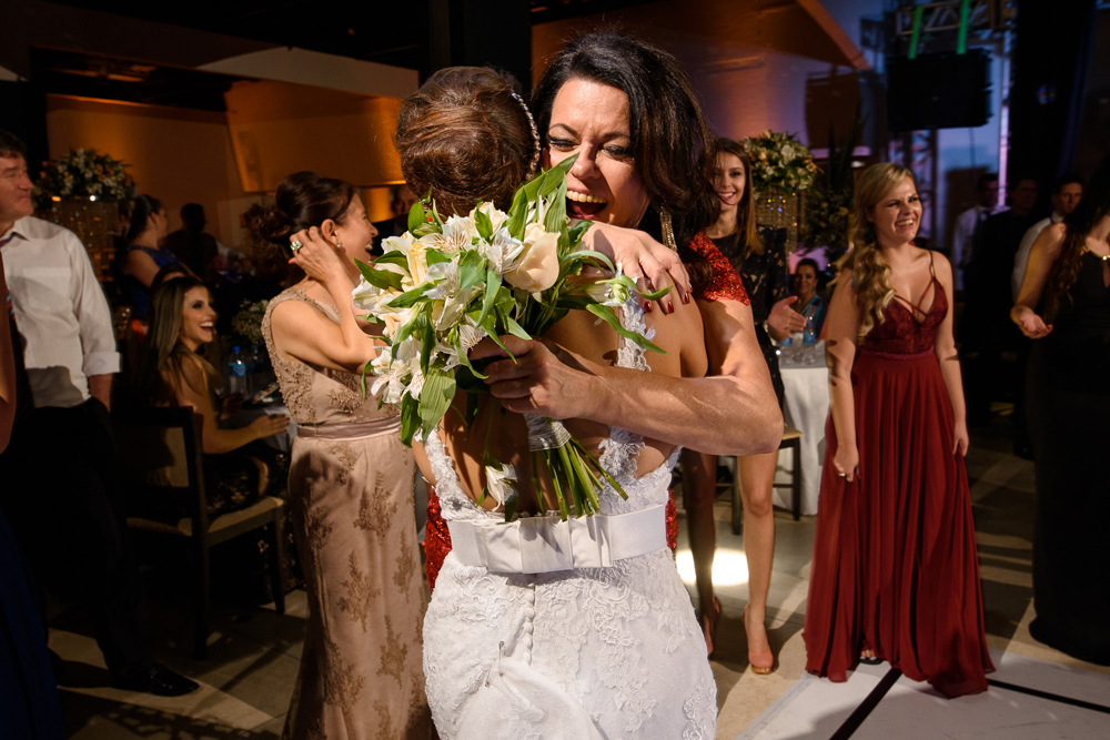 Abraço apertado da noiva em sua sogra no momento da entrega do bouquet