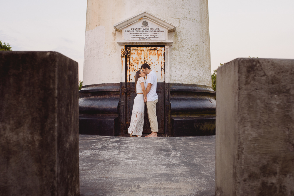 Foto distante dos noivos na porta do farol
