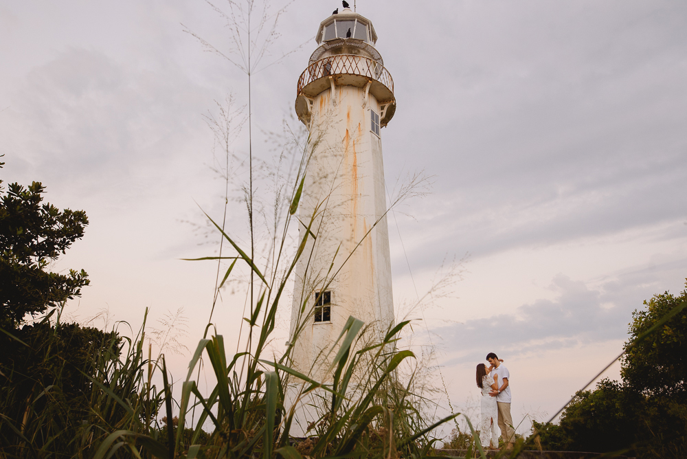 Noivos em cena com o farol da ilha