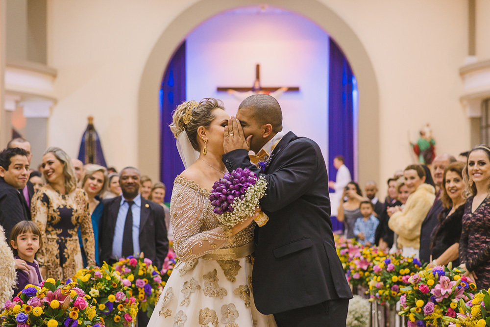 Noivo escondendo o beijo do casal na saída da igreja