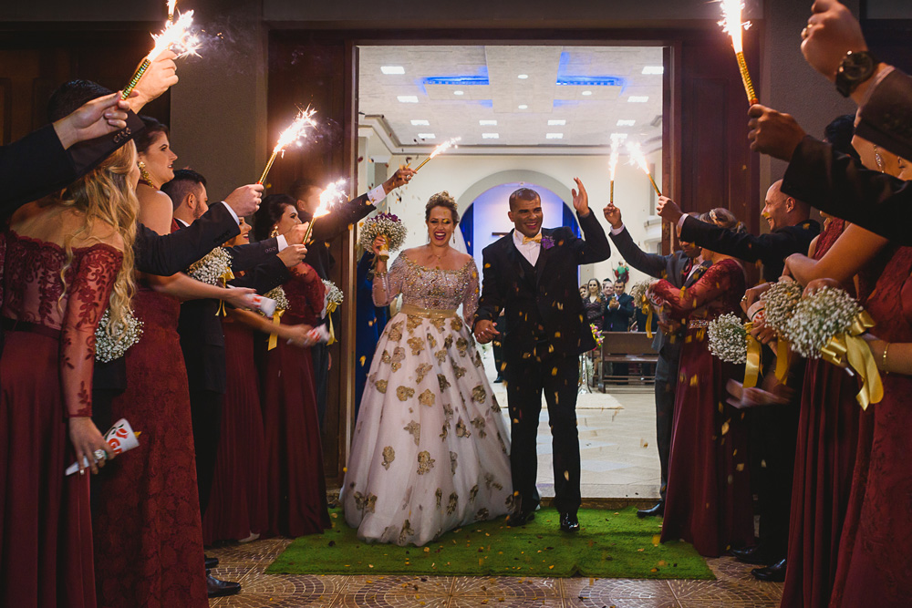 Noivos festejando com fogos na saída da igreja