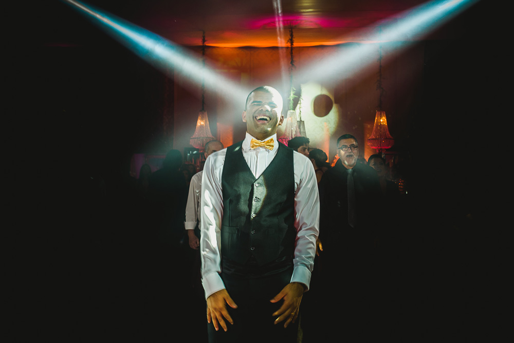 Noivo rindo com as luzes da balada nele