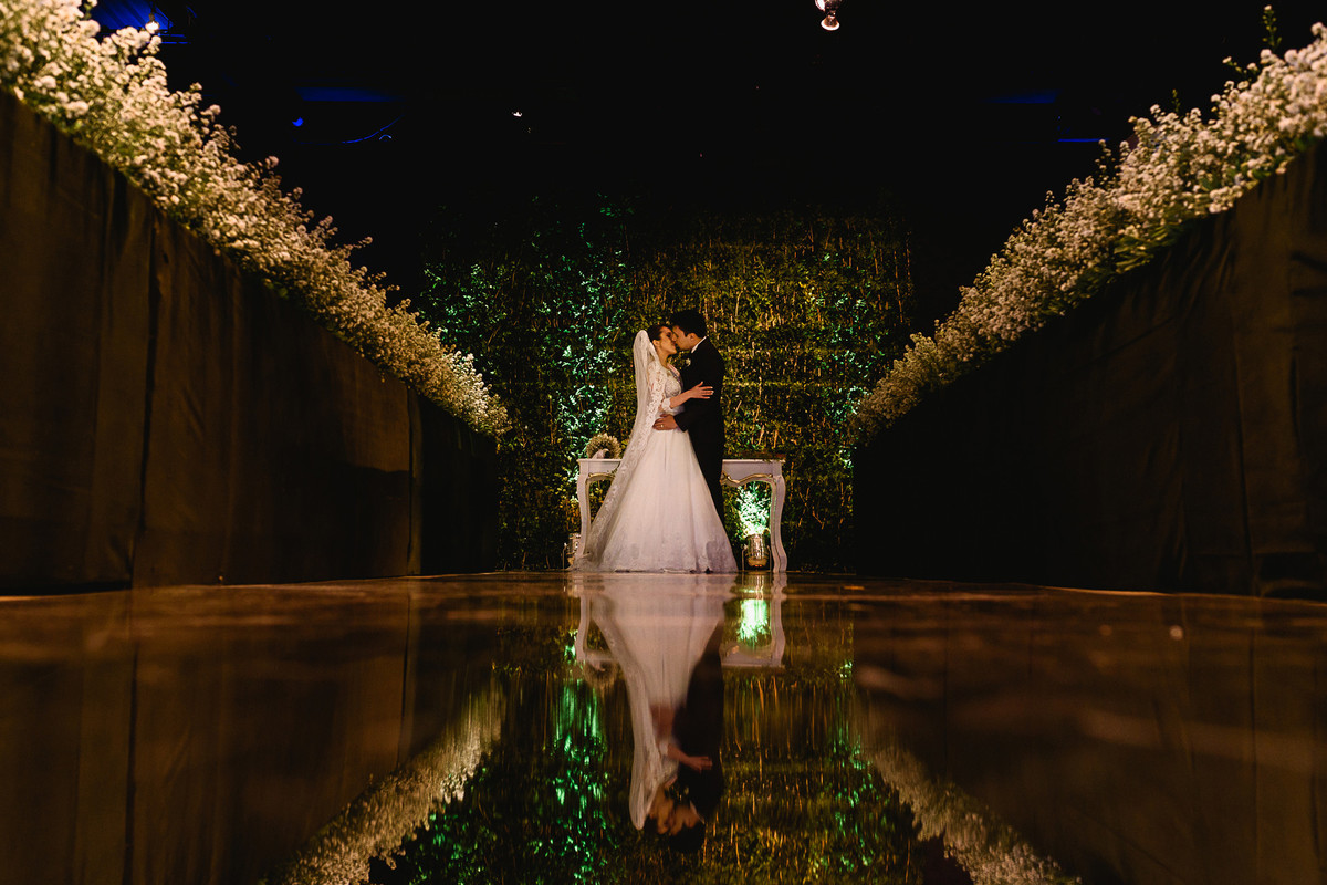 Beijo dos noivos com reflexo na passarela