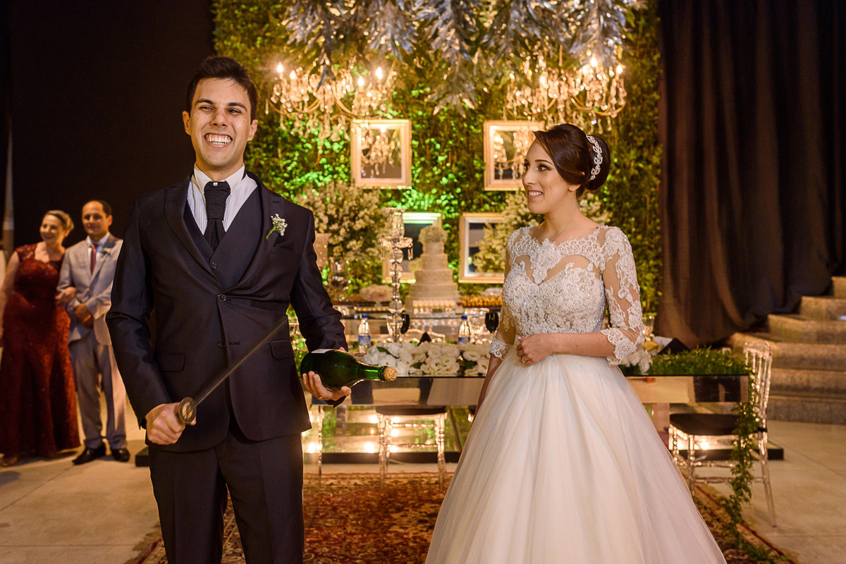 Noivo se preparando para abrir a garrafa com o saibre