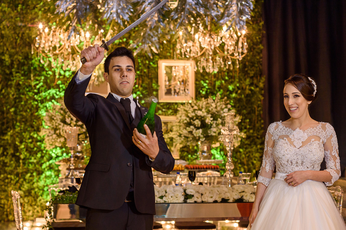 Noivo abrindo a garrafa com saibre