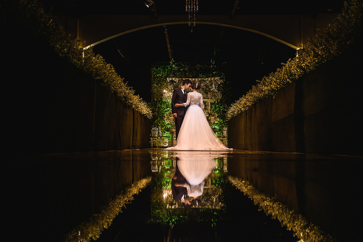 Foto dos noivos com reflexo na passarela