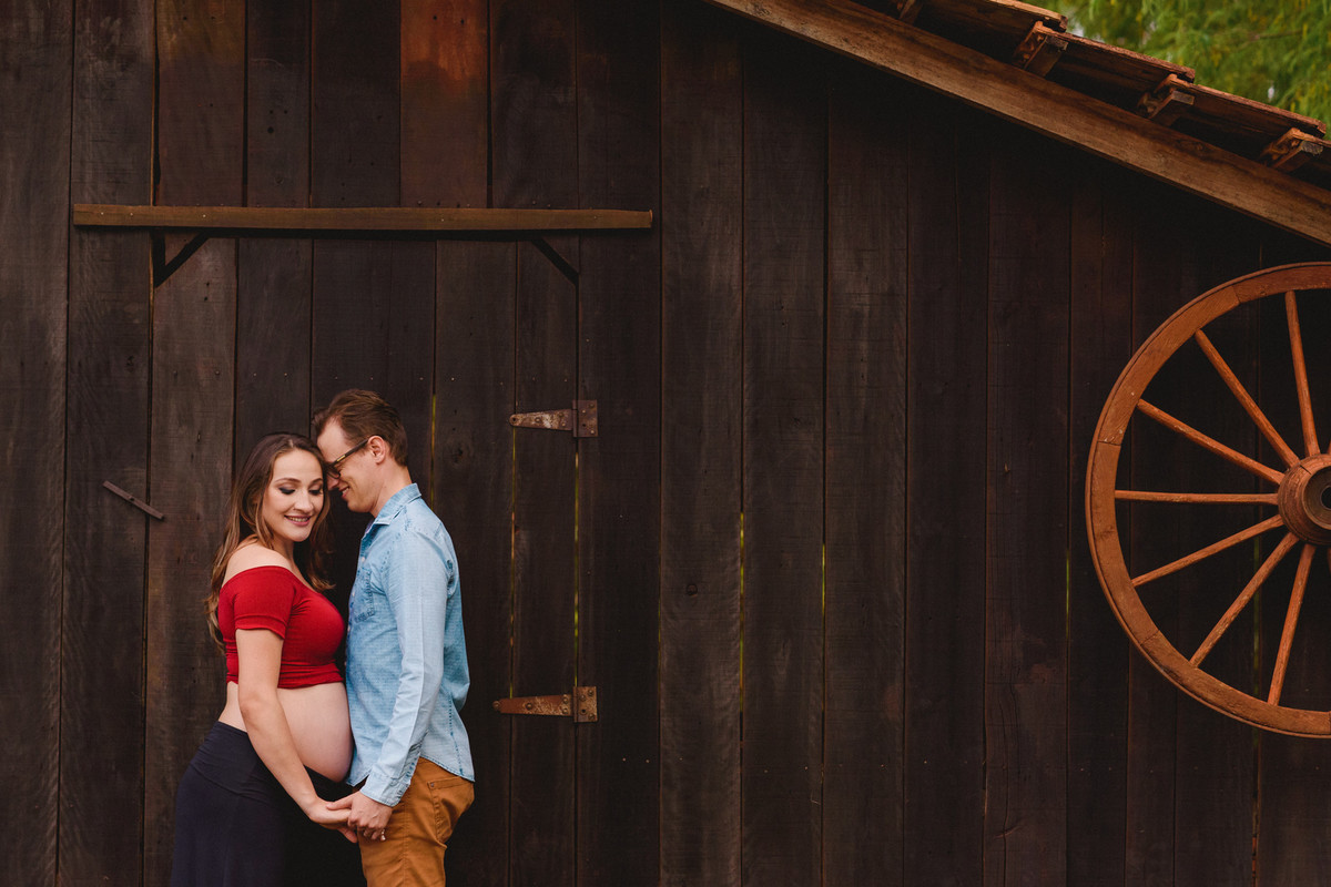 Casal em frente à uma parede de madeira
