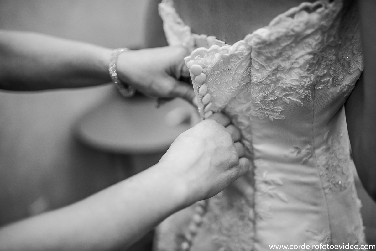 Mãe colocando vestido na noiva