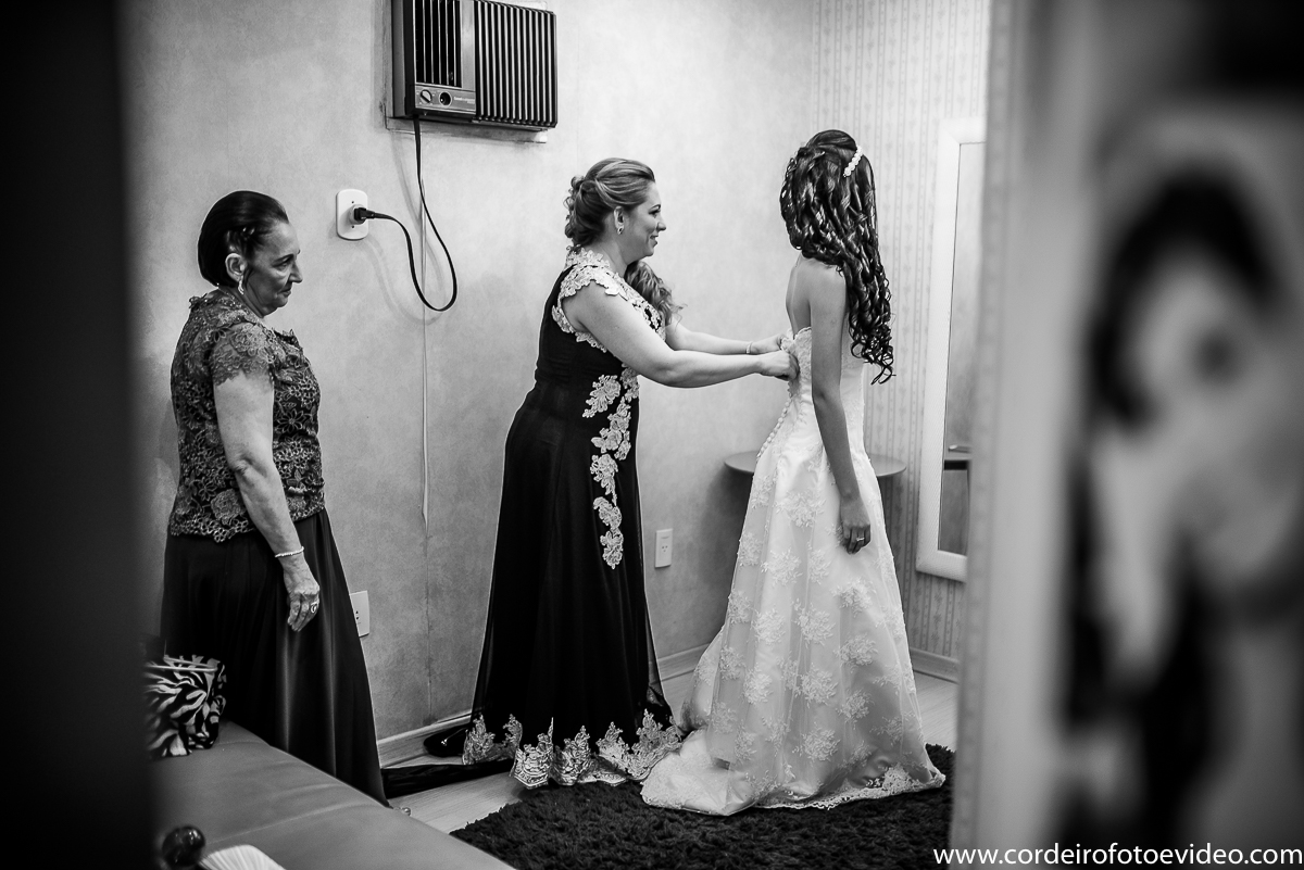 Mãe colocando vestido na noiva