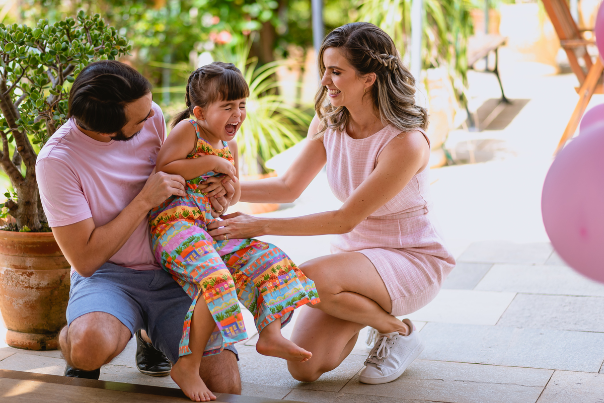 pai e mãe abraçando filha 