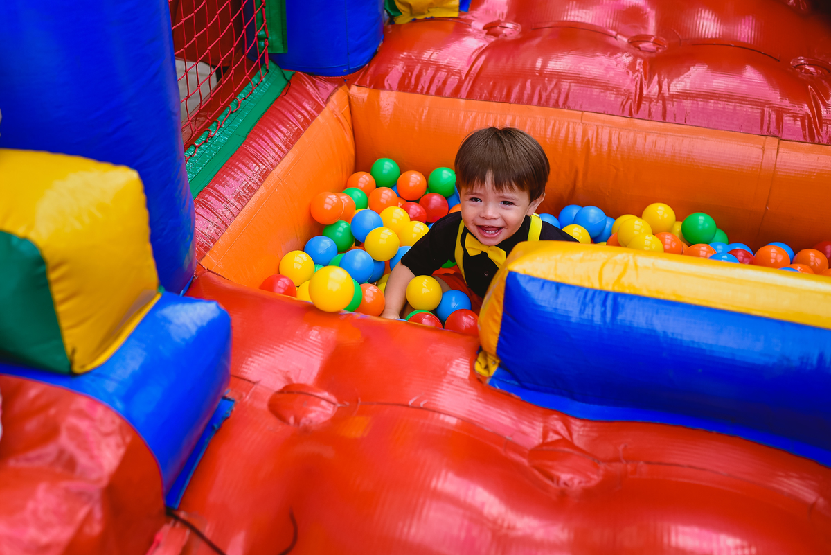 criança bancando na piscina de bolinhas 