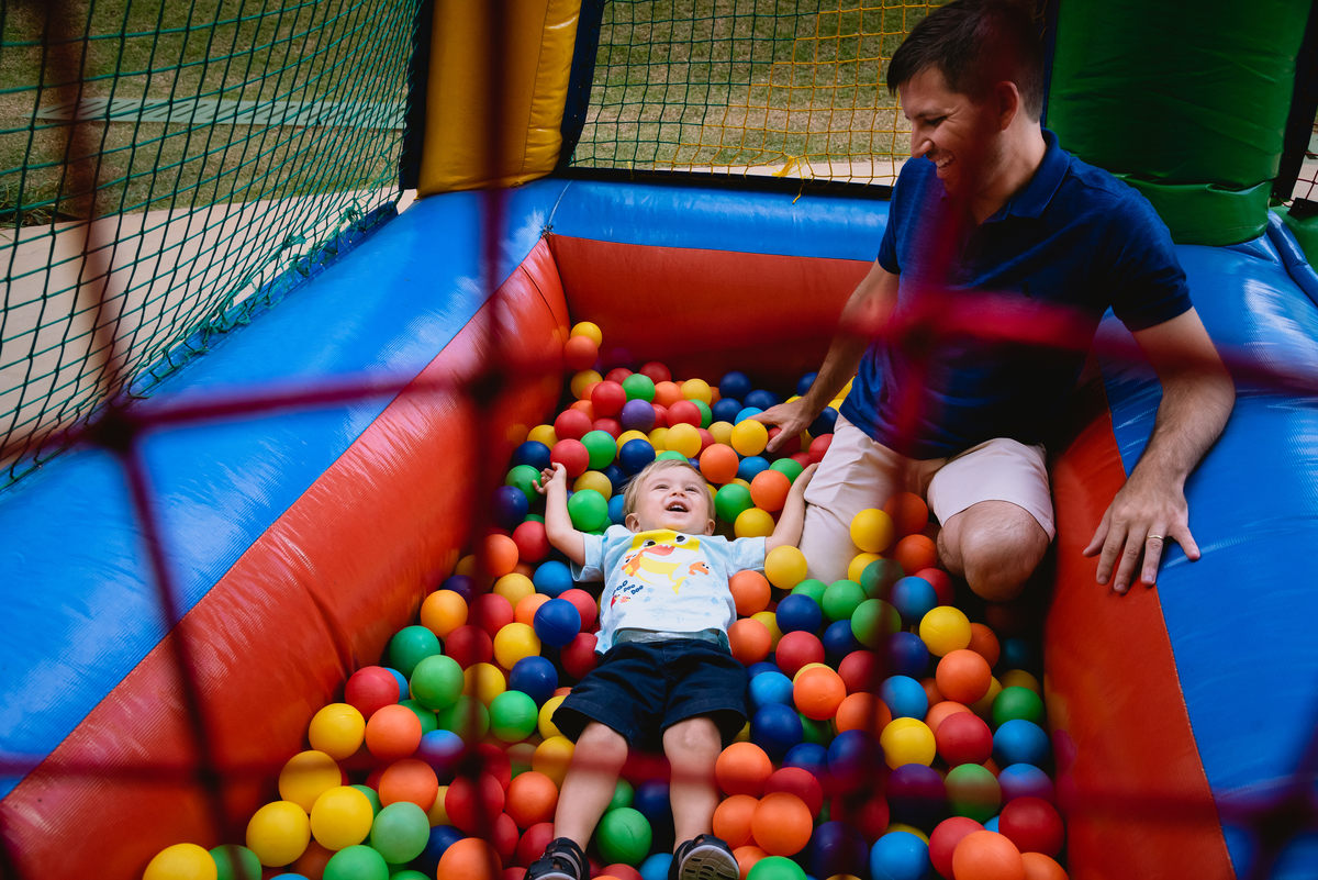 menino brincando na piscina de bolinha  com o pai