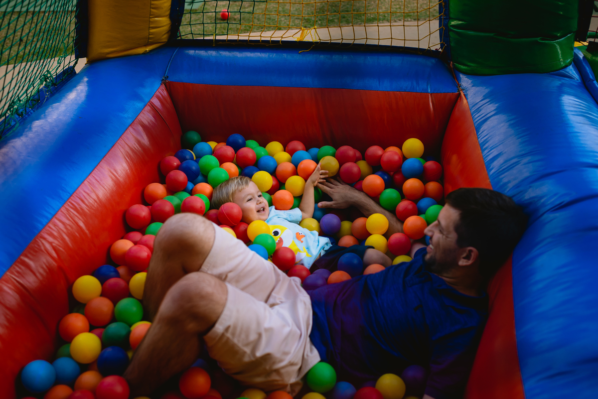 menino brincando na piscina de bolinha  com o pai
