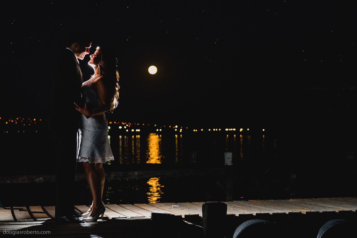 casal namorando com a vista da lua e o lago