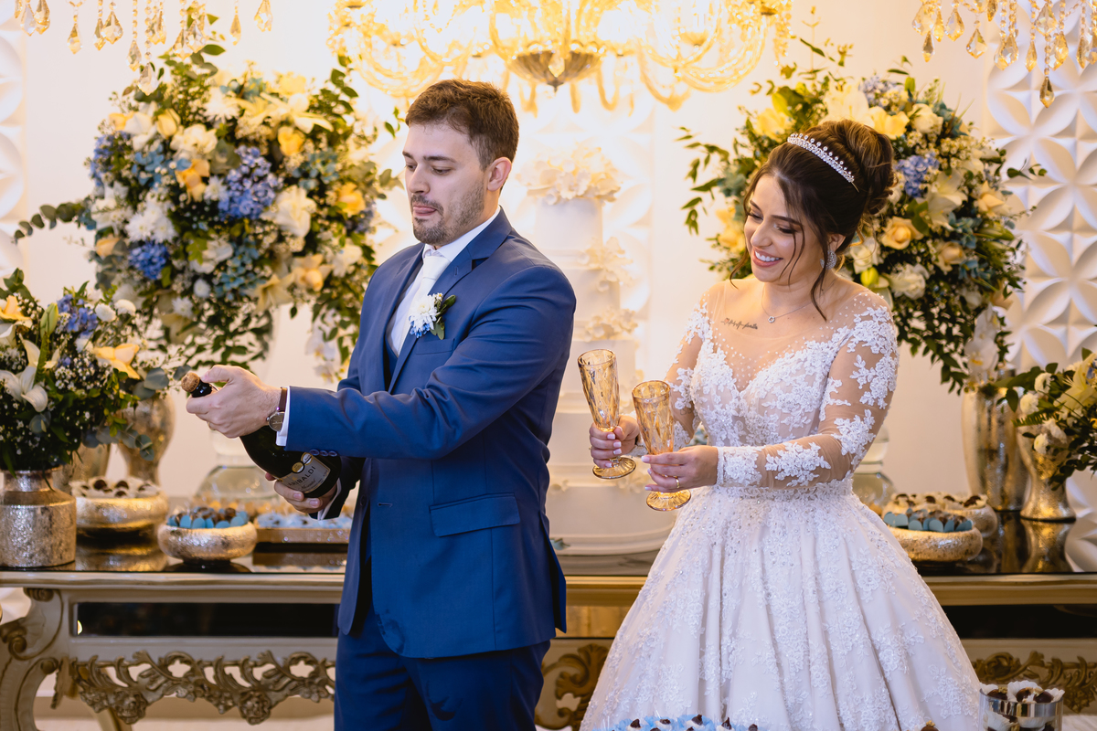 foto de casamento na mesa do bolo abrindo o champanhe