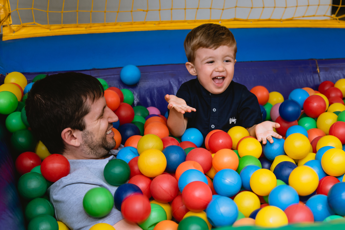 foto de festa festa infantil meino brincando com o pai na piscia de bolinhas
