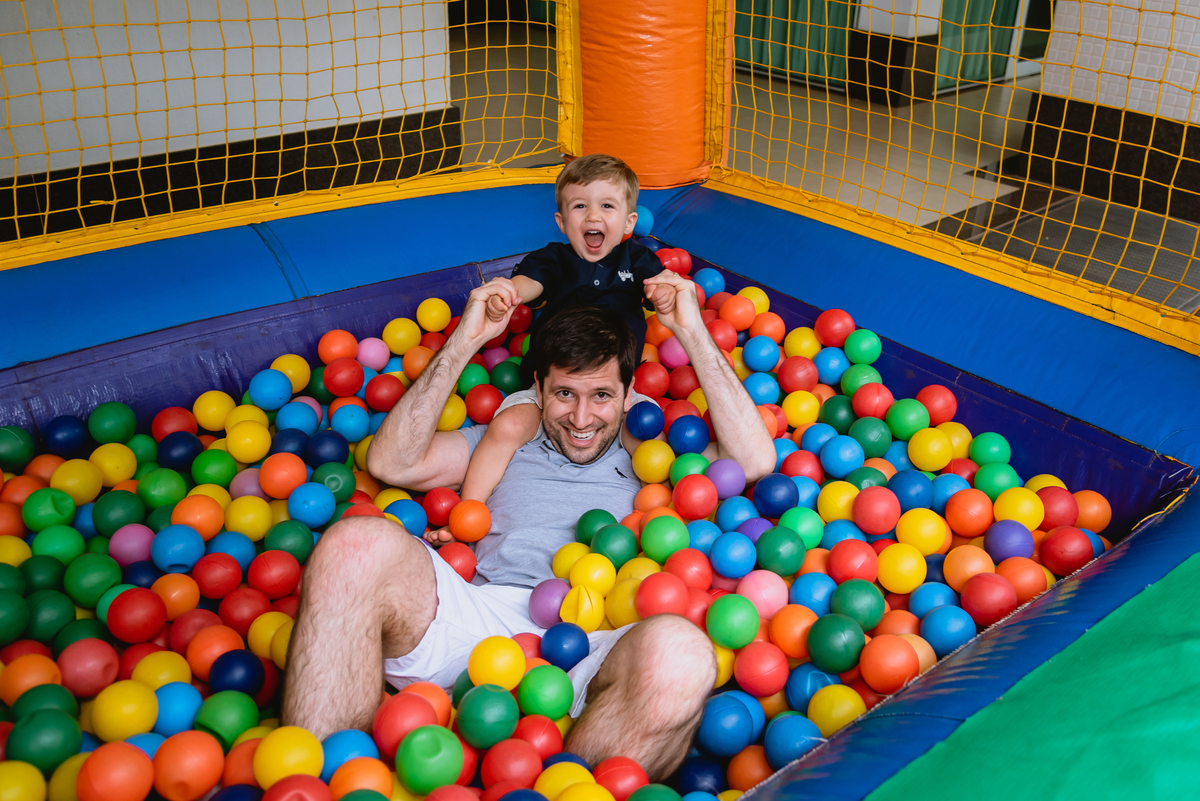foto de festa festa infantil meino brincando com o pai na piscia de bolinhas