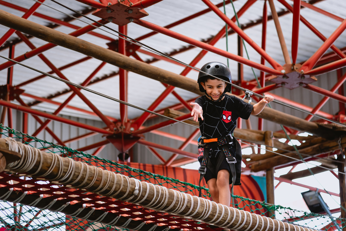 foto de menino brincando em arborismo 