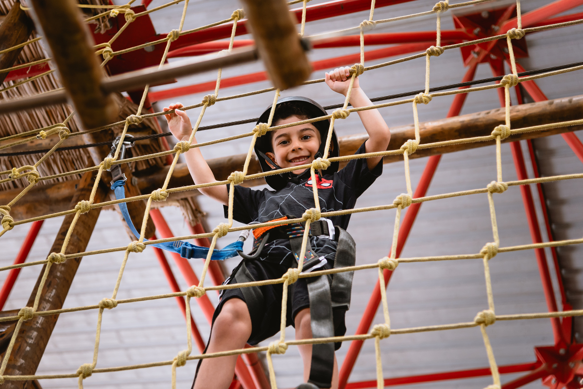 foto de menino brincando em arborismo 