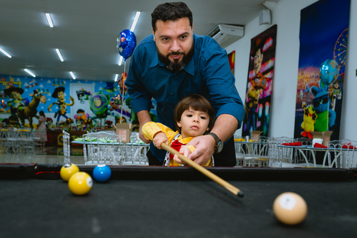 criança brincando com o pai de sinuca