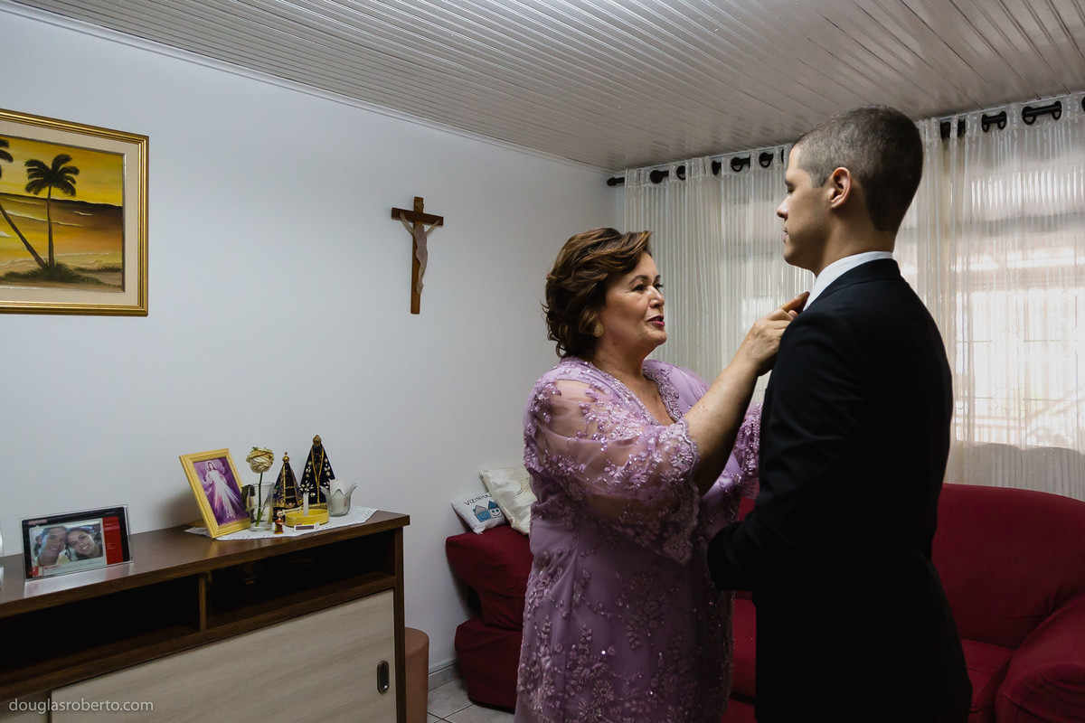 mãe do noivo arrumando o noivo