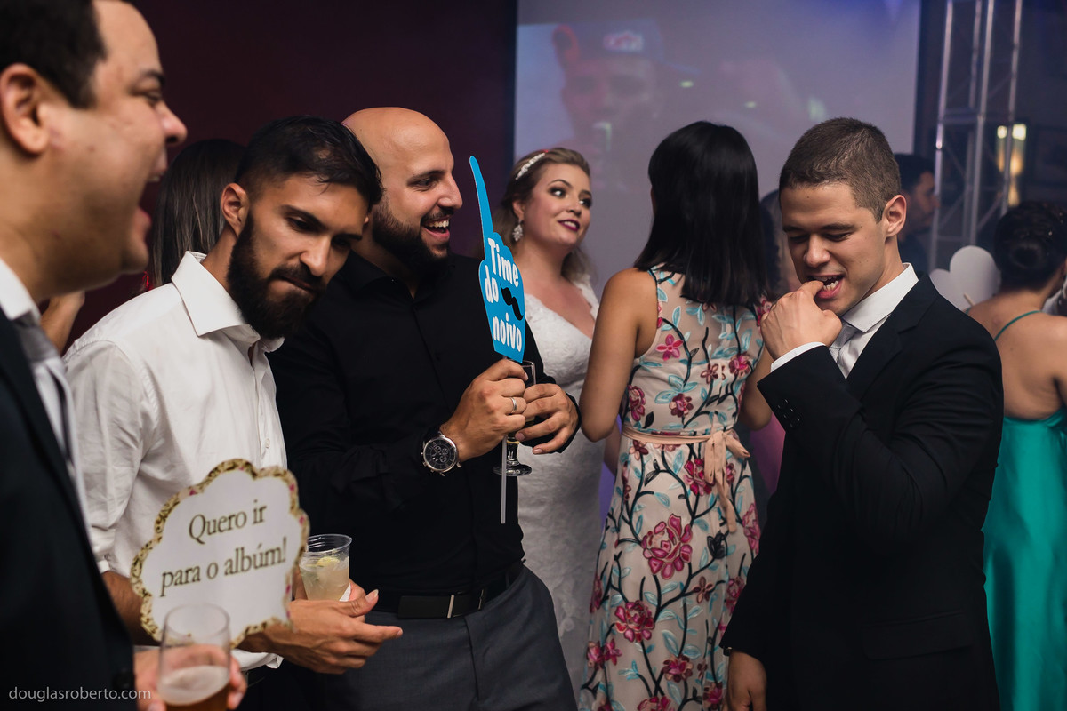 noivo dançando com os amigos na pista de dança