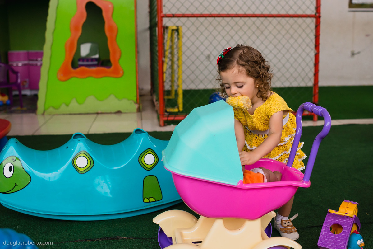 criança comendo milho e brincando