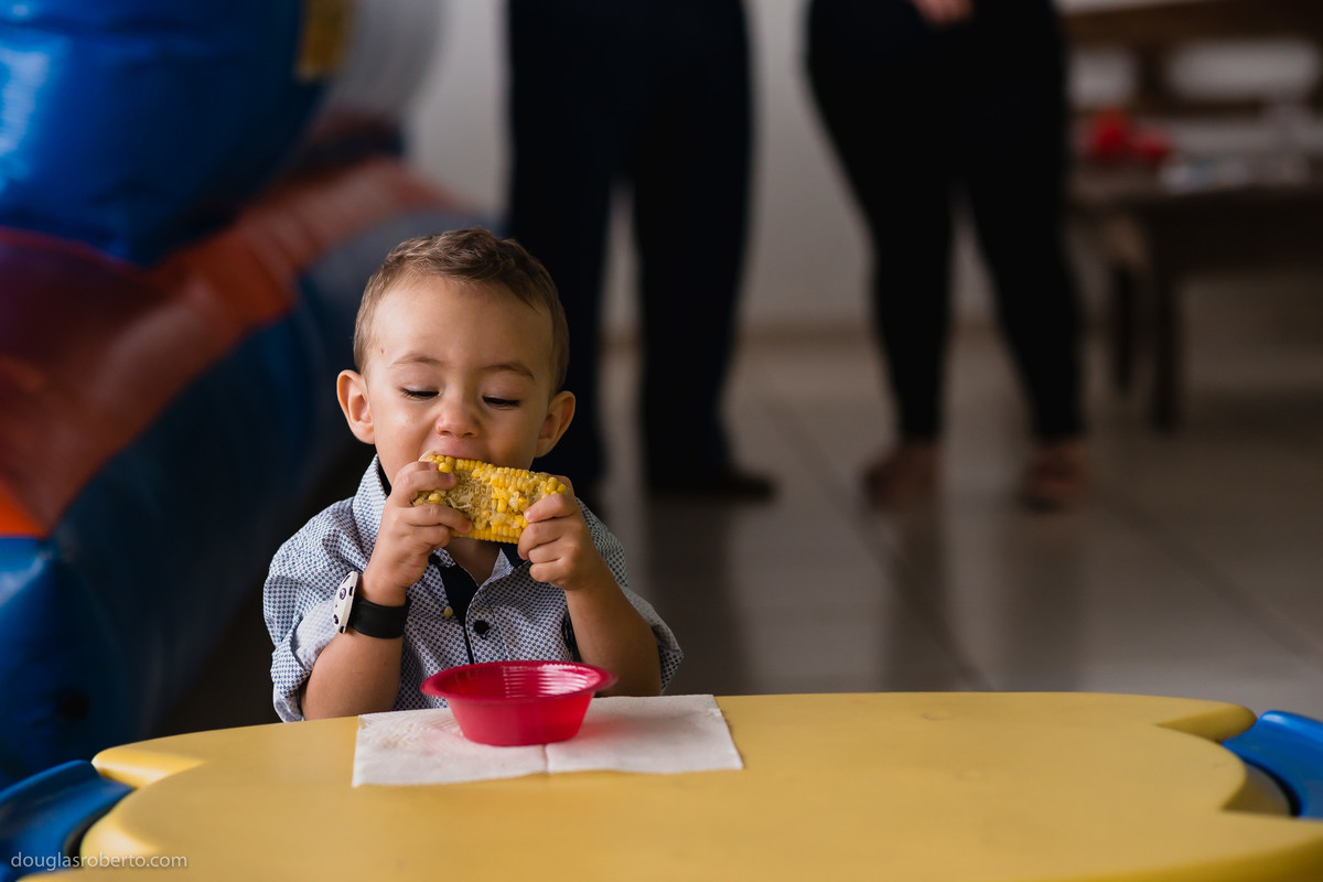 menino comendo milho em festa infantil