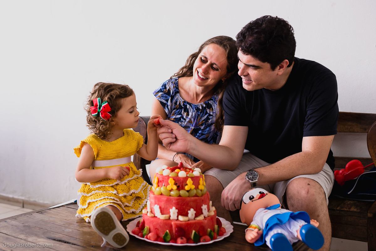 pai e mãe brincando com filha