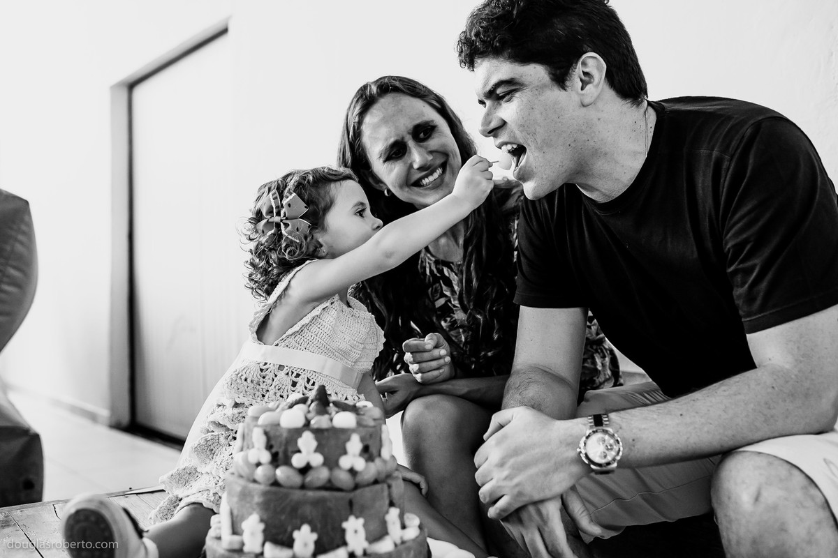 pai e mãe brincando com filha