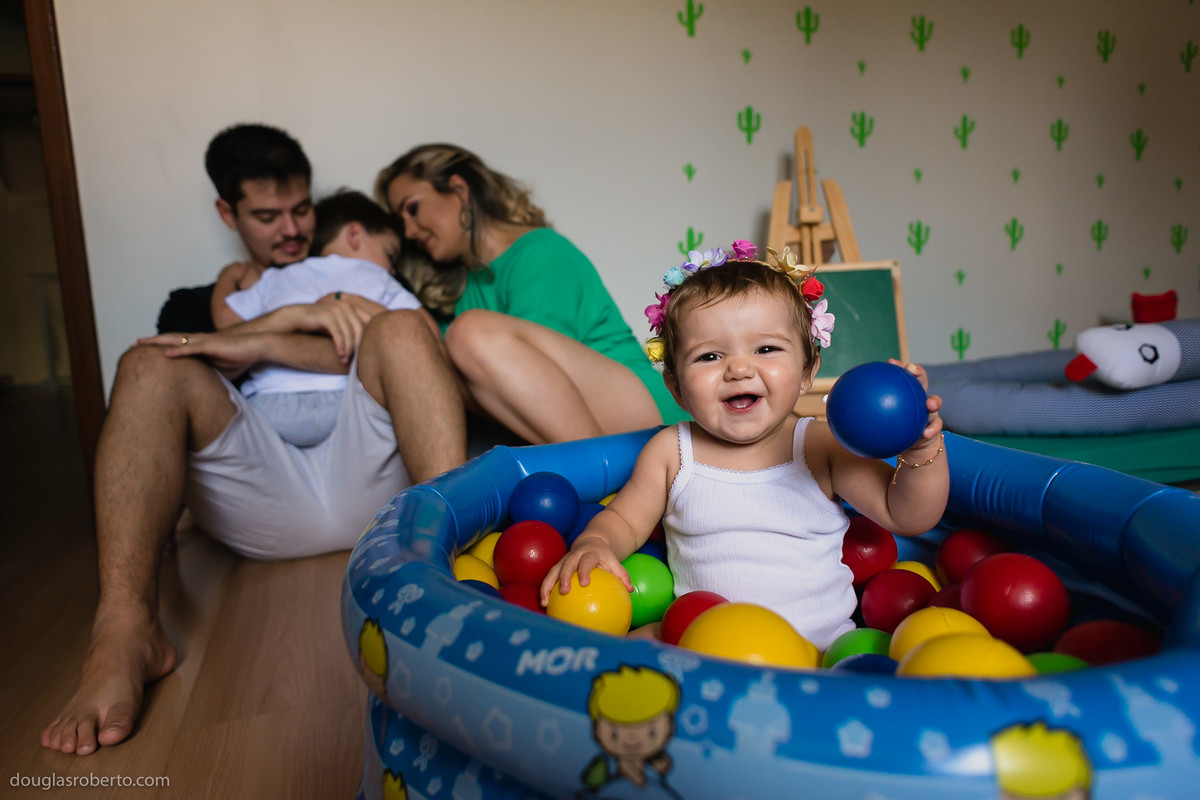 menina brincando na piscina de bolinas