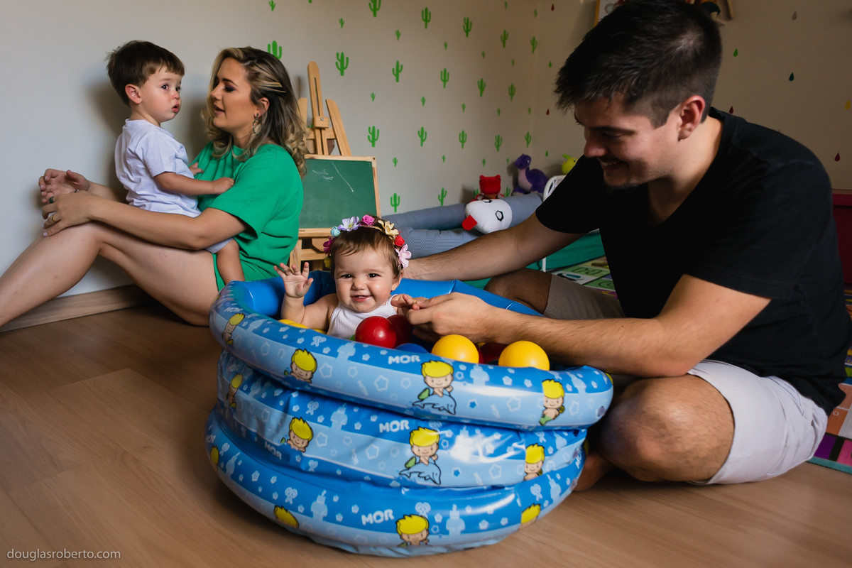 pai brincando com filha na piscina de bolinhas
