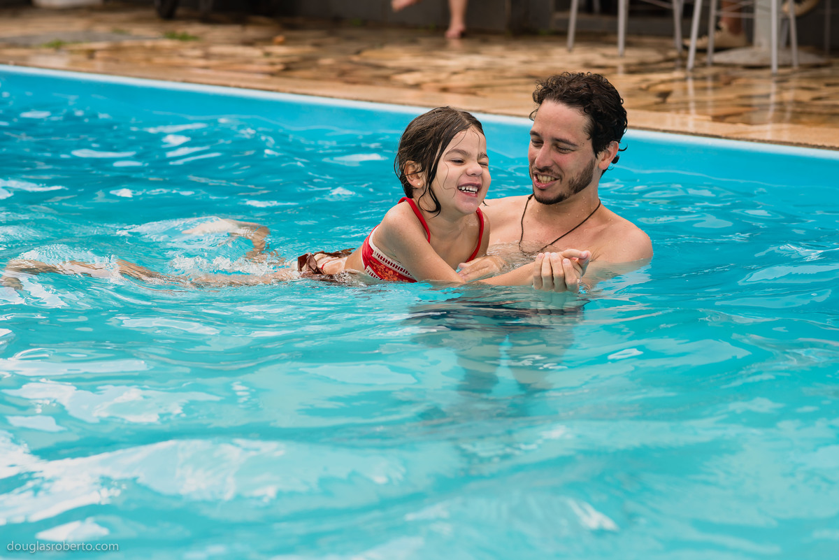 tio e sobrinha brincando na piscina