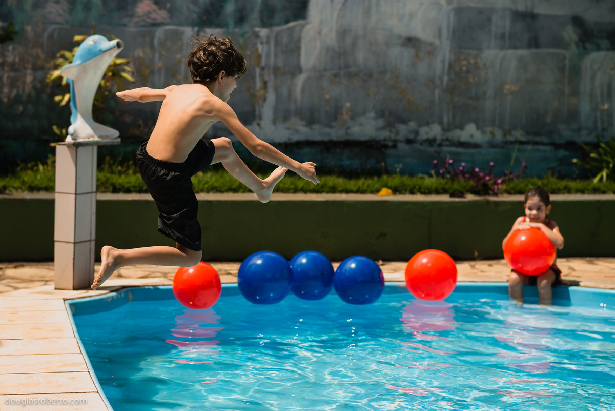 criança pulando na piscina