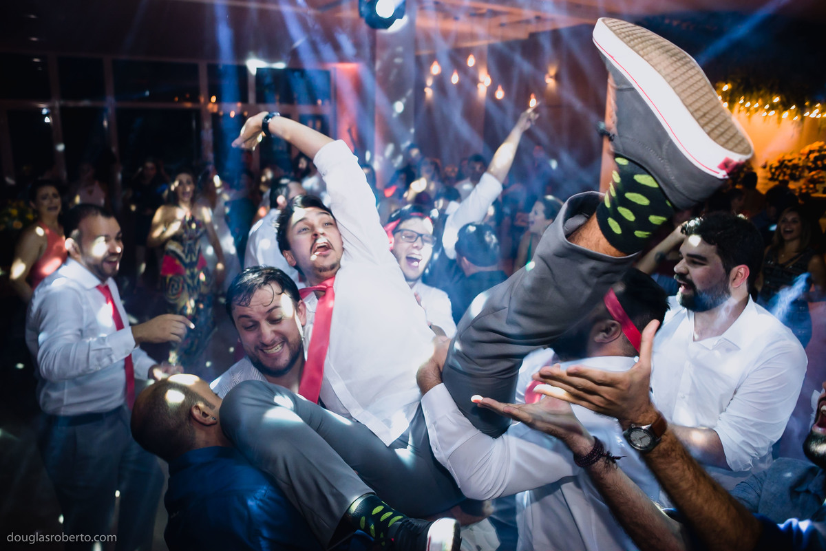 padrinhos jogando noivo para cima na pista de dança