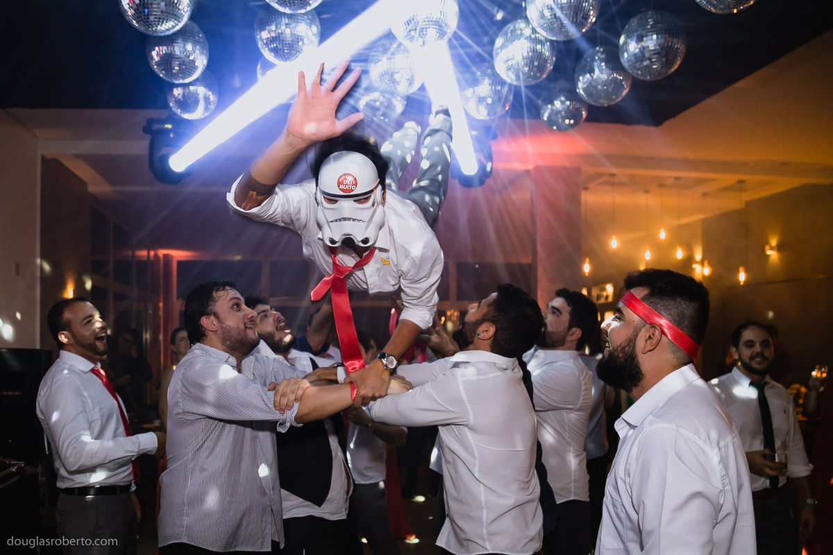padrinhos jogando noivo para cima na pista de dança