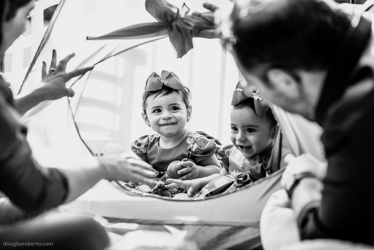 pais brincando com as filhas gêmeas 