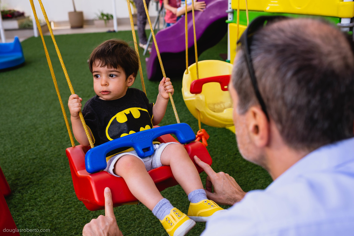 pai brincando com o filho no balanço