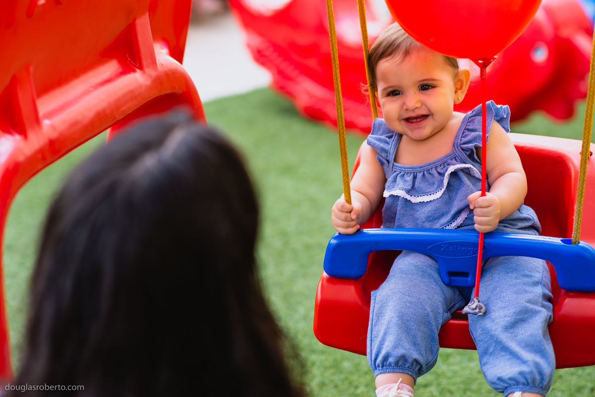 mãe brincando com filha no balanço