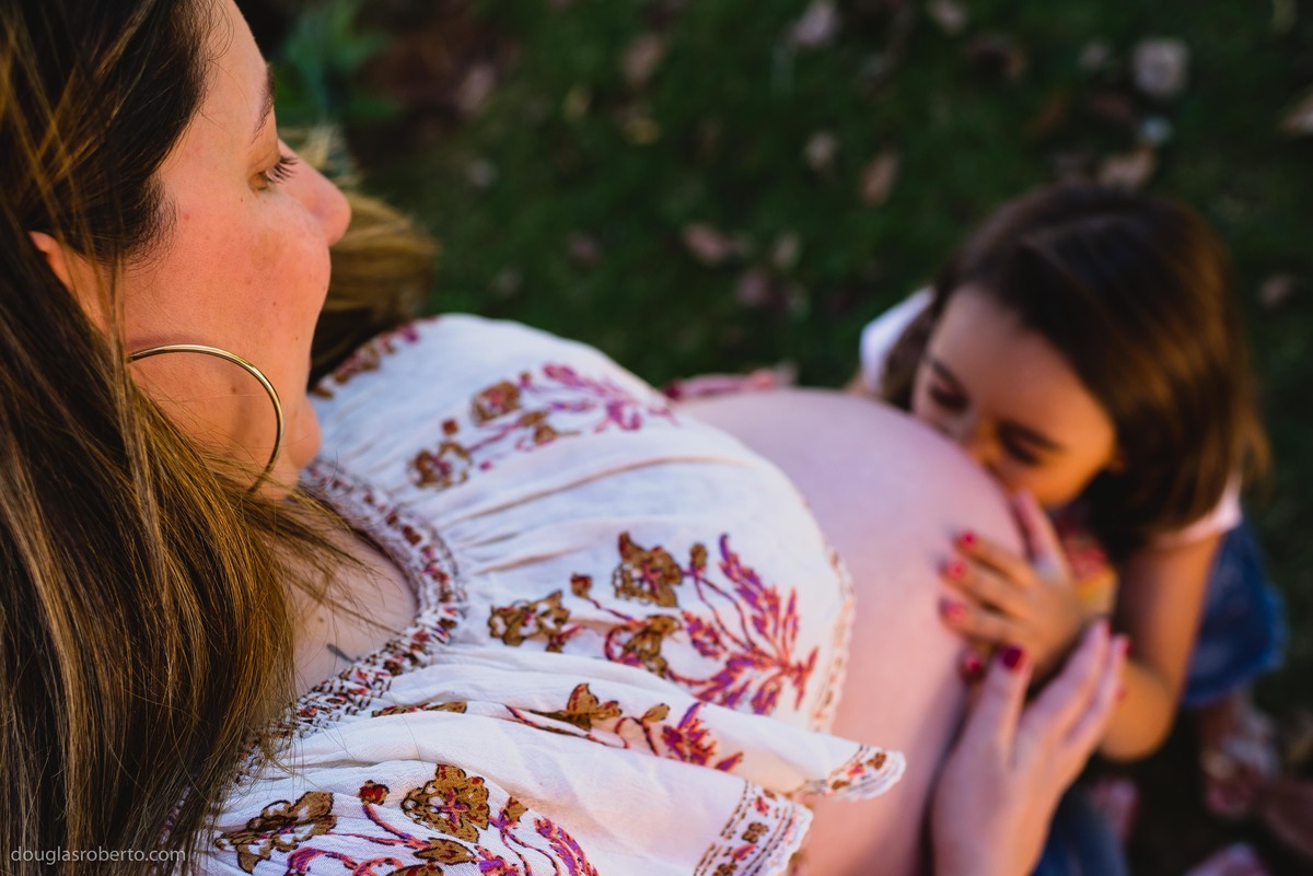 filha beijando a barriga da mãe