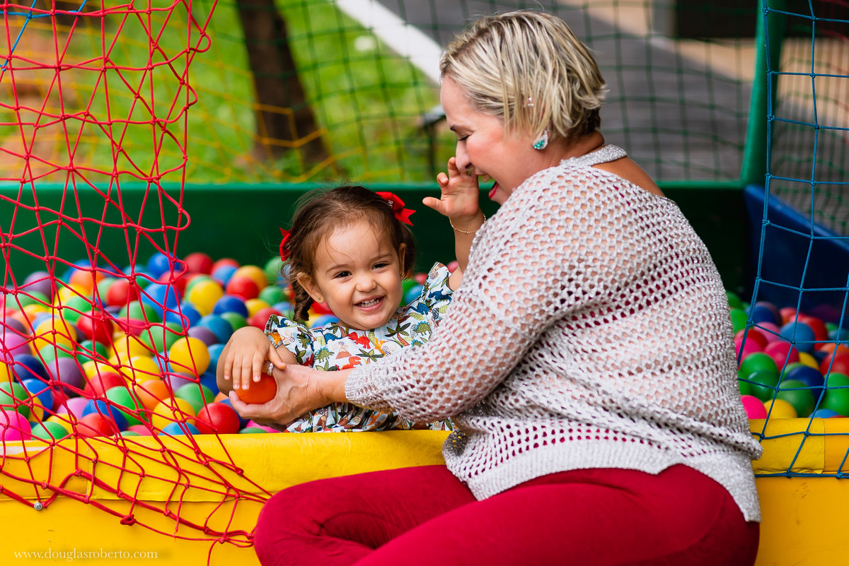 vó brincando com a neta na piscina de bolinhas