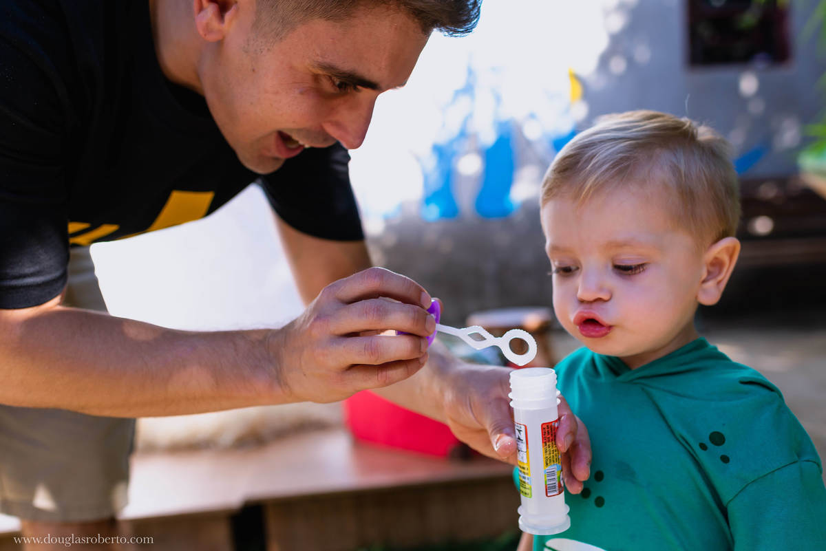 pai brincando com o filho de fazer bola de sabão