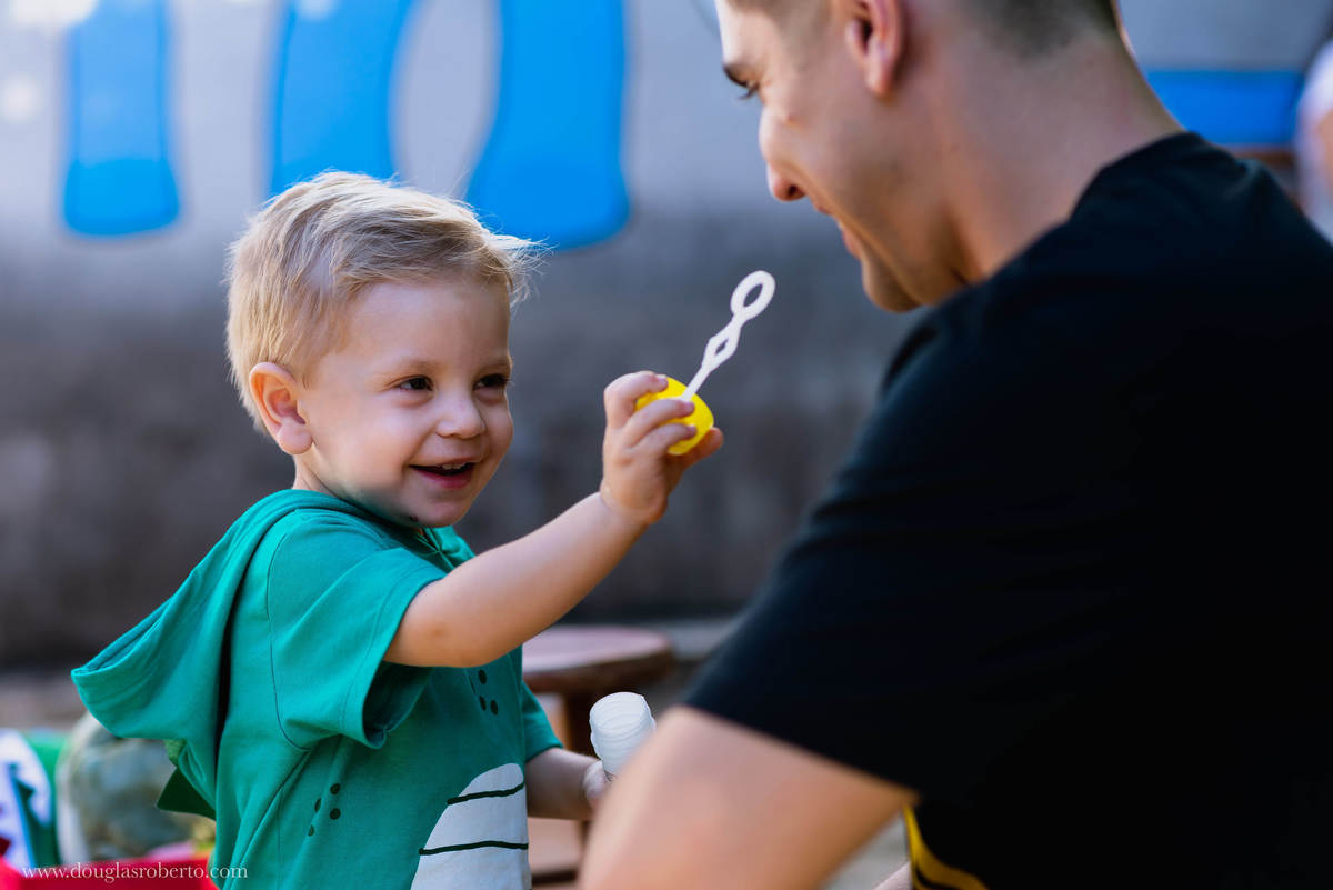 pai brincando com o filho de fazer bola de sabão