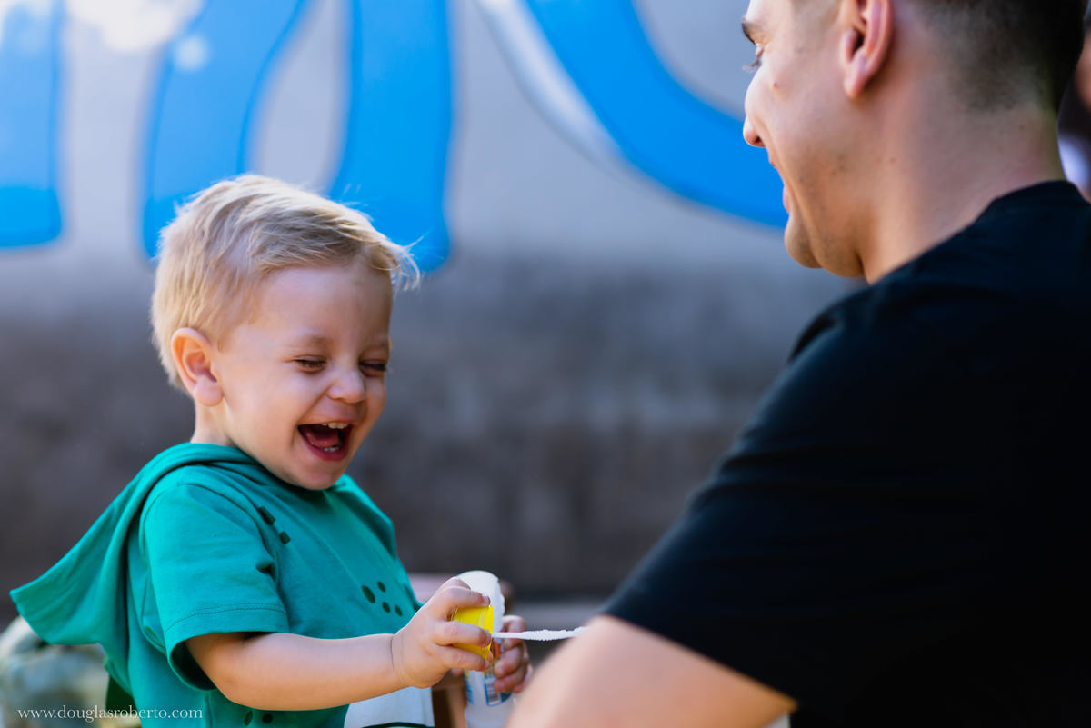 pai brincando com o filho de fazer bola de sabão