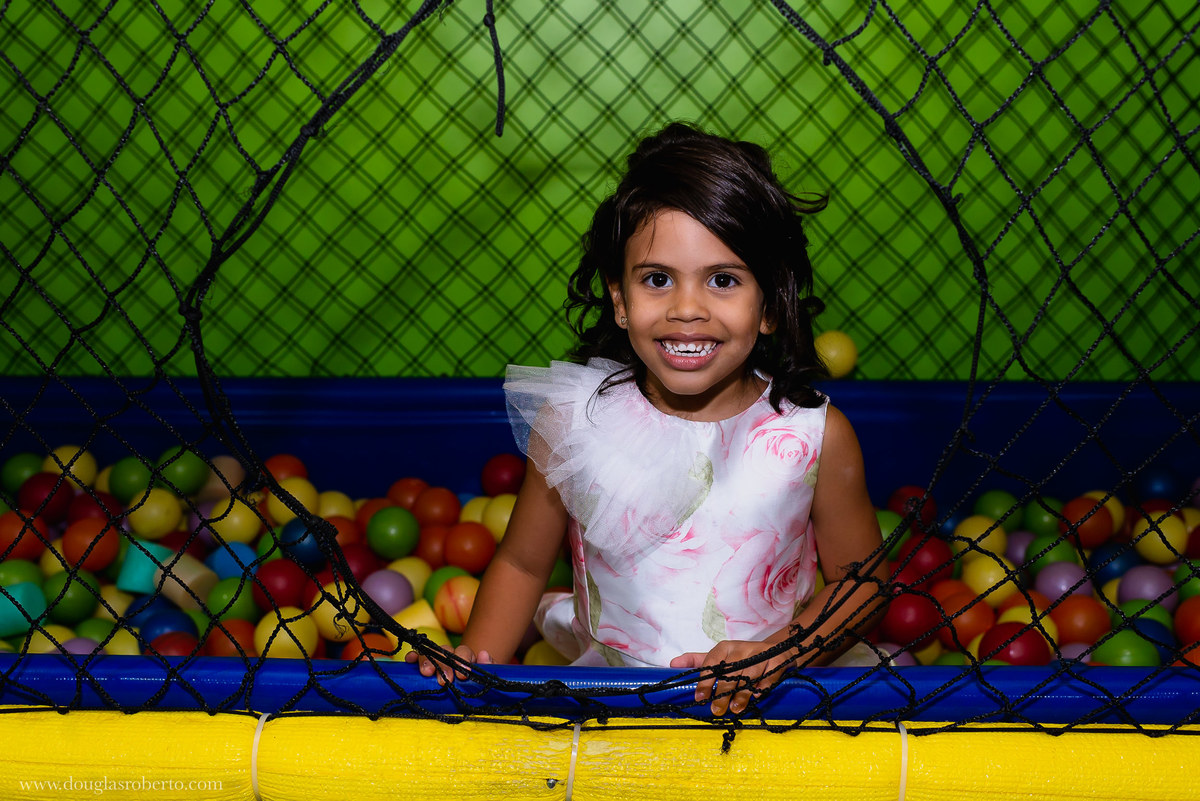 menina brincando na piscina de bolinhas