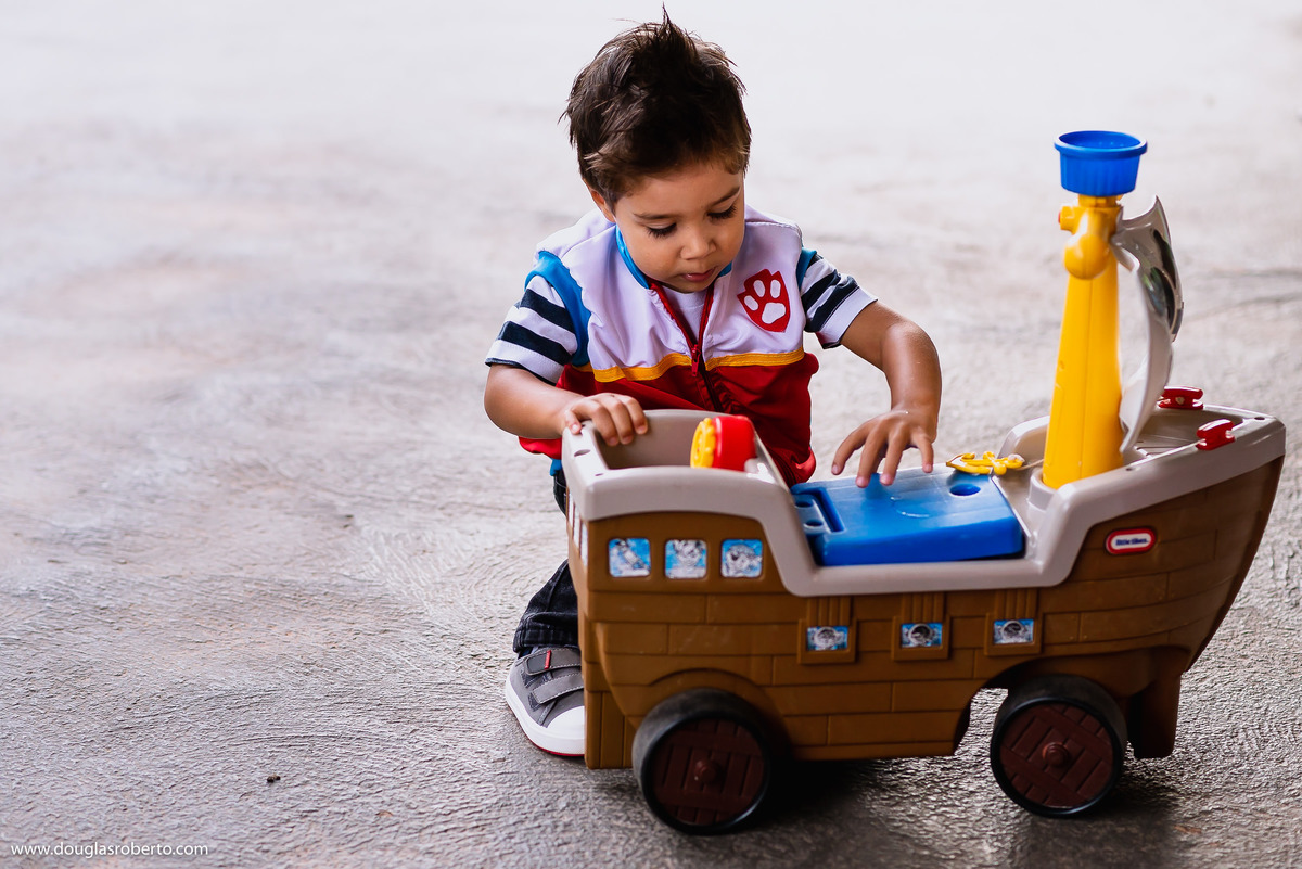 menino brincando com o barco pirata