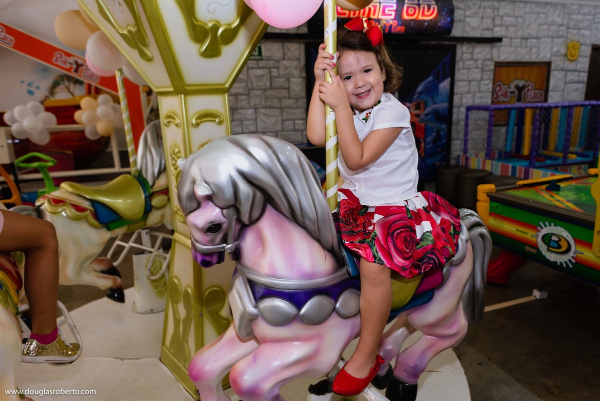menina brincando no carrossel 